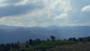 a field with trees and mountains in the background at Yacanto360 in Villa Yacanto
