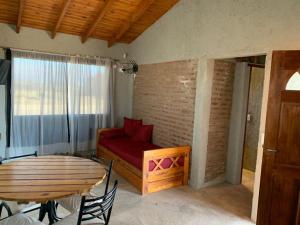 a living room with a red couch and a table at Yacanto360 in Villa Yacanto