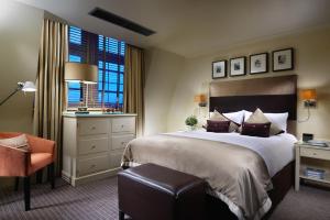 a hotel room with a bed, desk, and television at London Bridge Hotel in London