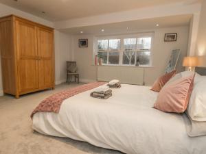 a large white bed in a bedroom with a window at Hare Cottage in Market Rasen