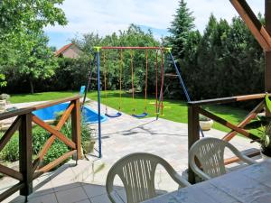 un columpio en un patio con parque infantil en Holiday Home Emöke - BGK105 by Interhome, en Balatonederics