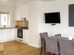 eine Küche mit einem Tisch und einem TV an der Wand in der Unterkunft Apartment Havsdalsgrenda - HLD103 by Interhome in Geilo