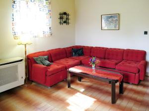 un sofá rojo en una sala de estar con mesa en Holiday Home János - FOD140 by Interhome, en Balatonfenyves