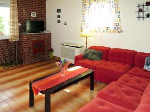 sala de estar con sofá rojo y chimenea en Holiday Home János - FOD140 by Interhome, en Balatonfenyves
