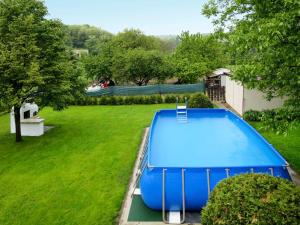 une piscine bleue dans une cour avec une pelouse verte dans l'établissement Holiday Home Pentaller - SZA341 by Interhome, à Balatonföldvár