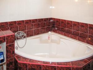 e bagno con vasca e piastrelle rosse. di Holiday Home Pentaller - SZA341 by Interhome a Balatonföldvár
