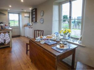 eine Küche mit einem Tisch und Teller mit Lebensmitteln darauf in der Unterkunft Rose Cottage in Monmouth