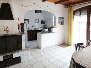 une cuisine avec un grand sol carrelé blanc et une table dans l'établissement Holiday Home Arvacska by Interhome, à Balatonmáriafürdő