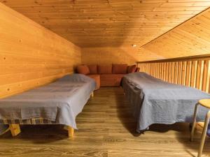 ユッラスヤルヴィにあるHoliday Home Tunturinvieri l1 by Interhomeのベッド2台とソファが備わる客室です。