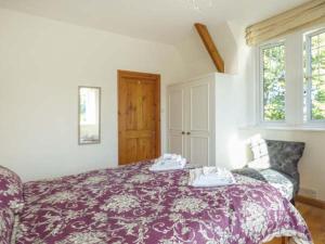 a bedroom with a bed with a purple blanket at The Old School House in Launceston