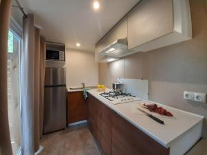 a kitchen with a stove and a refrigerator at Holiday Home Ponente Deluxe by Interhome in Marina di Bibbona