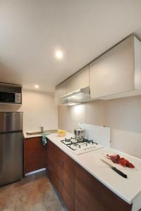 a kitchen with a stove and a refrigerator at Holiday Home Ponente Deluxe by Interhome in Marina di Bibbona