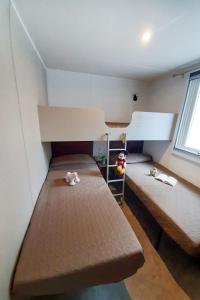 a small room with two bunk beds in it at Holiday Home Ponente Deluxe by Interhome in Marina di Bibbona +14 photos