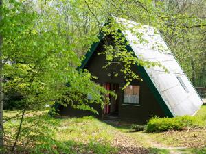 a small house with a pointed roof in the woods at Chalet Waldglück by Interhome in Bad Arolsen