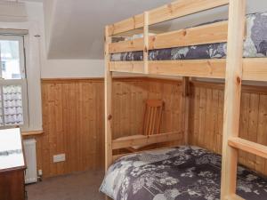 a bunk bed in a room with wooden walls at The Rest in Eyemouth