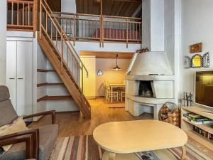 a living room with a table and a staircase at Holiday Home Ylläskakkonen b9 by Interhome in Ylläsjärvi