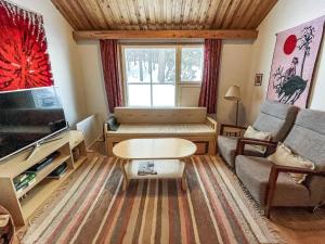 een woonkamer met een bank en een tv bij Holiday Home Ylläskakkonen b9 by Interhome in Ylläsjärvi