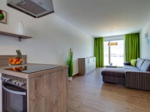 a kitchen and living room with green curtains and a couch at Apartment Piratennest by Interhome in Großpösna