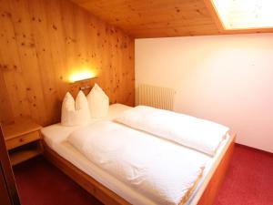 sypialnia z białym łóżkiem i drewnianymi ścianami w obiekcie Apartment Elisabeth by Interhome w Alpbach