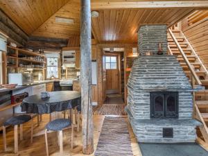 ユッラスヤルヴィにあるHoliday Home Ylläsparit as- mustikka by Interhomeのログキャビン内のキッチン(石造りの暖炉付)
