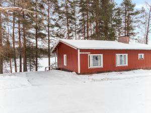 ターコブオリにあるHoliday Home Rantamökki by Interhomeの雪中の木々の赤い家