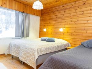 ターコブオリにあるHoliday Home Rantamökki by Interhomeのベッド2台 木製の壁の部屋