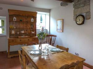 a dining room with a table and a clock on the wall at The Old Forge in Haworth