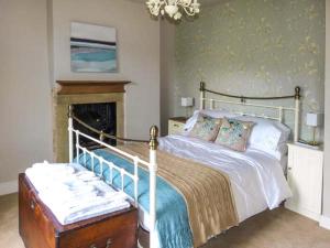 1 dormitorio con 1 cama grande y chimenea en The Old Forge en Haworth