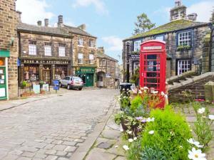 a red phone booth on a street in a city at The Old Forge in Haworth