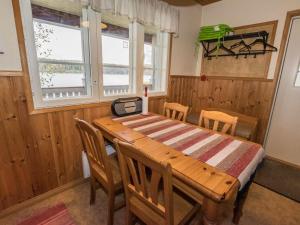 a dining room with a wooden table and chairs at Holiday Home Satulinna by Interhome in Matildedal