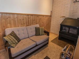 a living room with a couch and a stove at Holiday Home Satulinna by Interhome in Matildedal