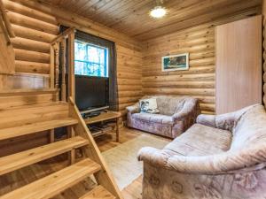 Cabaña de madera con sala de estar con 2 sofás y TV en Holiday Home Elimäki by Interhome, en Heinjoki