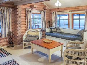 uma sala de estar com um sofá, cadeiras e uma mesa em Holiday Home Päivärinne by Interhome em Mäkisauru