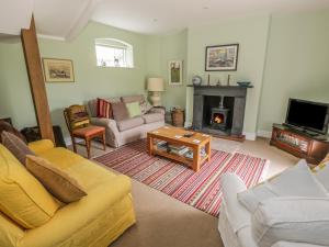 a living room with a couch and a fireplace at Bryn Howell Stables in Trevor