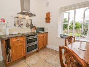 a kitchen with a table and a stove top oven at Bryn Howell Stables in Trevor