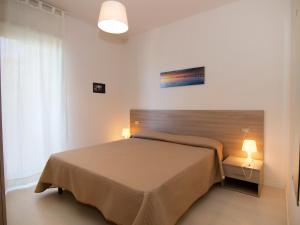 ポルト・ダスコリにあるApartment Cala Luna-2 by Interhomeのベッドルーム1室(ベッド1台、ランプ2つ、窓付)
