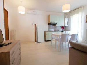 una cucina e una sala da pranzo con tavolo e sedie di Apartment Cala Luna-2 by Interhome a Porto dʼAscoli