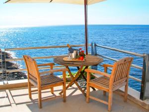 a table and chairs on a balcony with the ocean at Studio La Rosa-5 by Interhome in Plemmirio