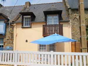 un parapluie bleu sur une clôture blanche devant une maison dans l'établissement Holiday Home Terrelabouet by Interhome, à Cancale