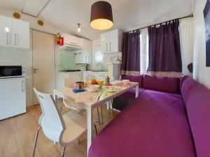 a living room with a purple couch and a table at Holiday Home Ostro by Interhome in Marina di Bibbona