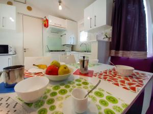 a kitchen with a table with a bowl of fruit on it at Holiday Home Ostro by Interhome in Marina di Bibbona
