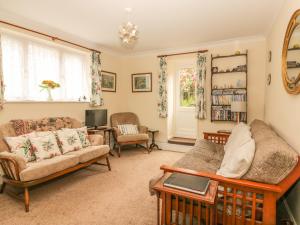 a living room with a couch and a tv at Little Acre in Torquay