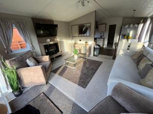 a living room with two couches and a tv at Hazel Oaks in Morpeth