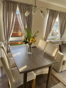 a dining room table with chairs and a vase of flowers on it at Hazel Oaks, Beautiful Lodge with Hot Tub - Sleeps 6 - Felmoor Park in Morpeth +43 photos