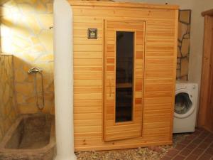 een houten douchecabine in een badkamer met een wasmachine bij Holiday Home Chrastov by Interhome in Černov