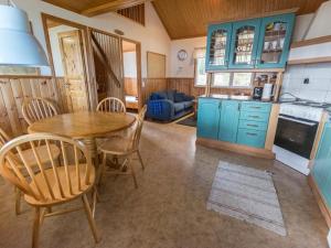 a kitchen with a wooden table and chairs in a room at Holiday Home Meritähti by Interhome in Mathildedal