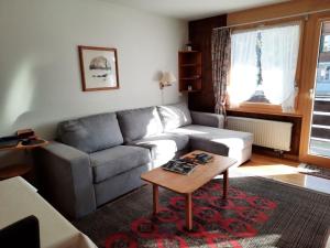 - un salon avec un canapé et une table dans l'établissement Apartment Mösli - Zimmerli by Interhome, à Zweisimmen