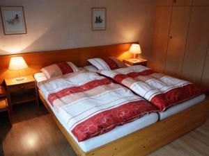 ツヴァイジンメンにあるApartment Mösli - Zimmerli by Interhomeのベッドルーム(ランプ2つ付)の大型ベッド1台