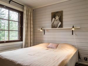 una camera da letto con un letto e un dipinto sul muro di Holiday Home Tahkovuorentie 34 b by Interhome a Tahkovuori