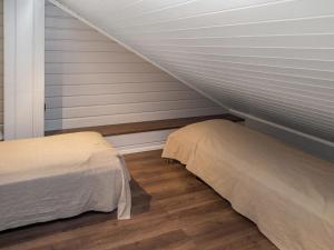 Cette chambre mansardée comprend deux lits et un escalier. dans l'établissement Holiday Home Tahkovuorentie 34 b by Interhome, à Tahkovuori 6 autres photos